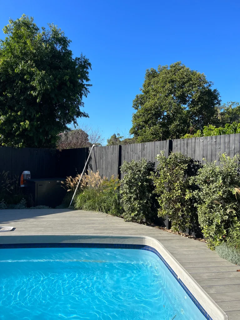 Blue pool framed by paving and boundary planting