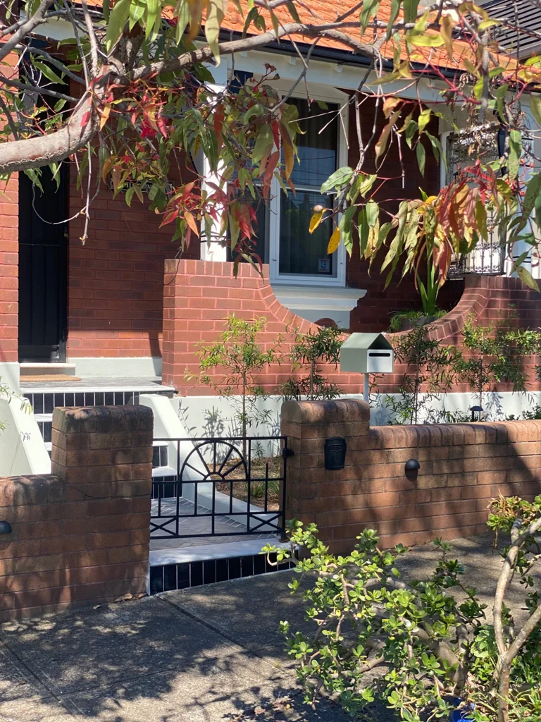 Wilga House brick facade framed by garden planting