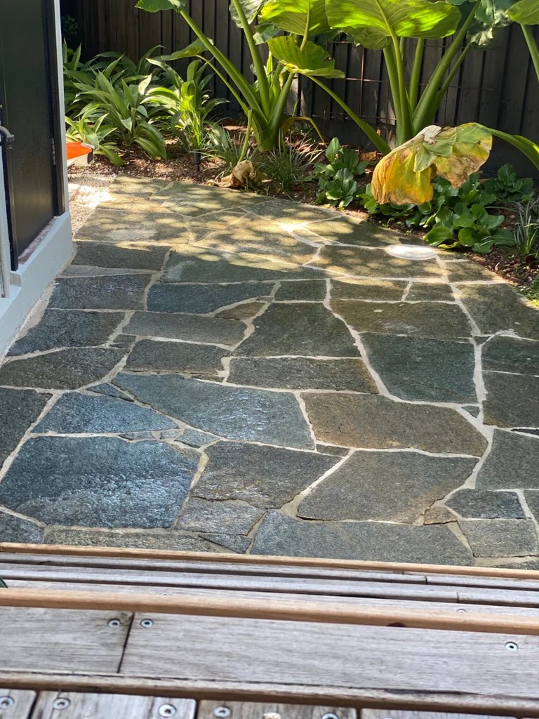 Irregular stone paving beside layered green planting