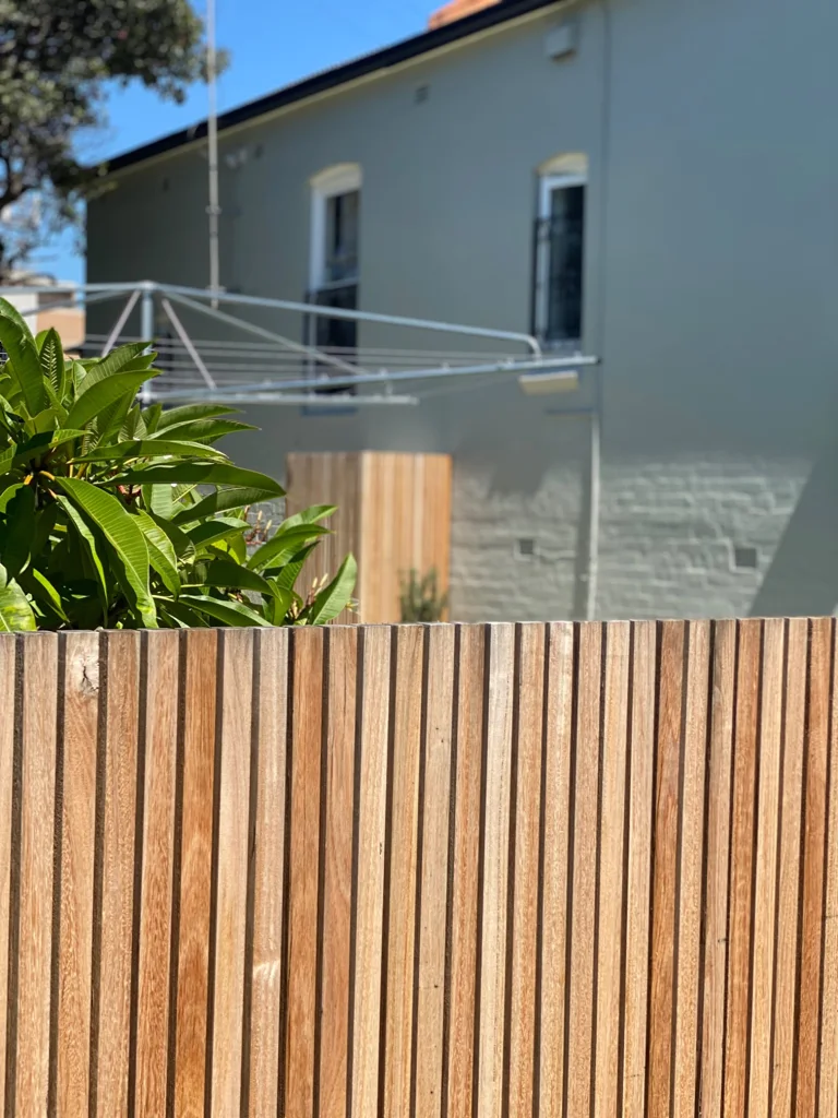 Timber fencing beside the house and leafy planting